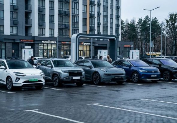 Лінійка з п'яти китайських електромобілів на міській парковці біля зарядної станції.